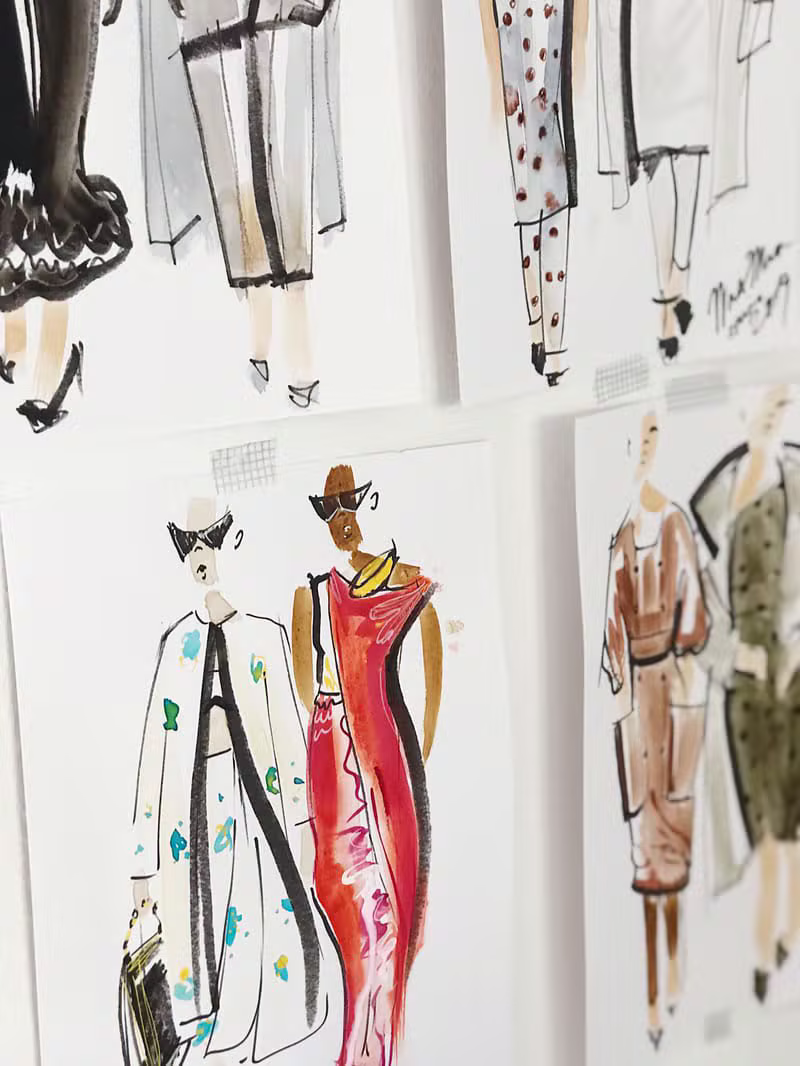 Hand-drawn couture sketches on a studio table